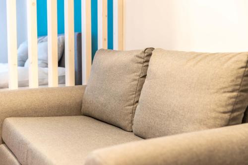 a couch with a pillow next to a crib at Munich Home in Munich