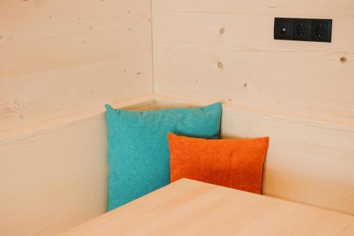 two blue and orange pillows in a room at Alpin - Studios & Suites in Warth am Arlberg