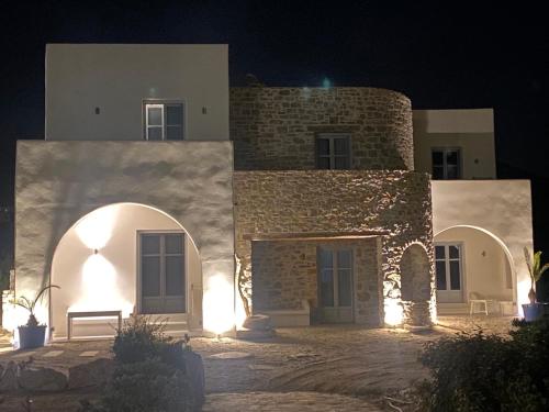 カタポラにあるThomas Villas on the beach Katapolaの白壁と夜間の扉のある建物