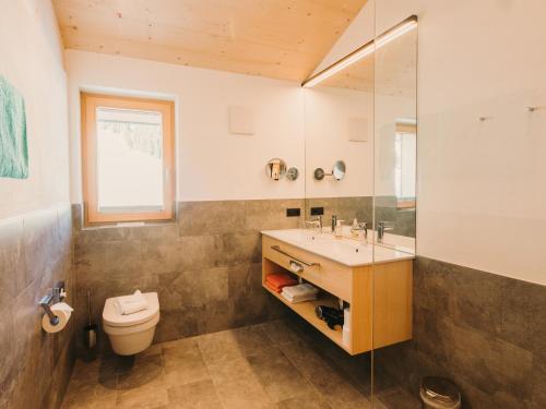 a bathroom with a sink and a toilet at Alpin - Studios & Suites in Warth am Arlberg