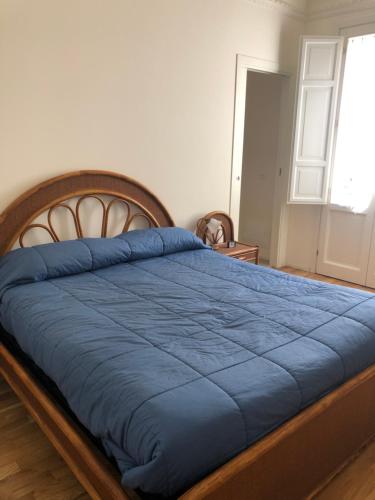 a bedroom with a bed with a blue blanket at Bijou Apartment in Trapani