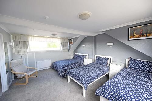 um pequeno quarto com 2 camas e uma cadeira em The Hathaways em Stratford-upon-Avon