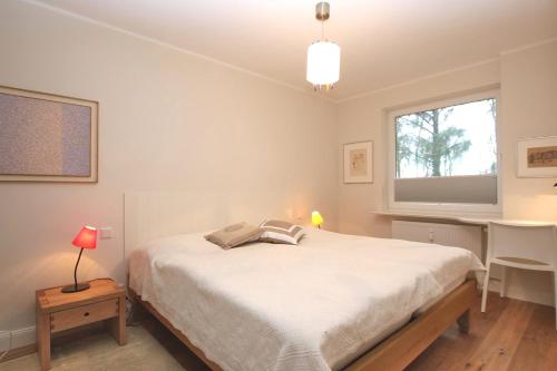 Schlafzimmer mit einem Bett, einem Schreibtisch und einem Fenster in der Unterkunft Am Grünstreifen 16, Waldeck, Whg. Nr.3 in Wyk auf Föhr