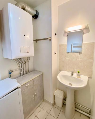 une petite salle de bain avec un lavabo et des toilettes dans l'établissement L'entre port & mer - Vue mer - Proxi gare plage & quai - Hyper-Centre - Parking gratuit, à Dieppe