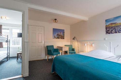 a hotel room with a bed and a desk and chairs at Hotelletje de Veerman in Oost-Vlieland