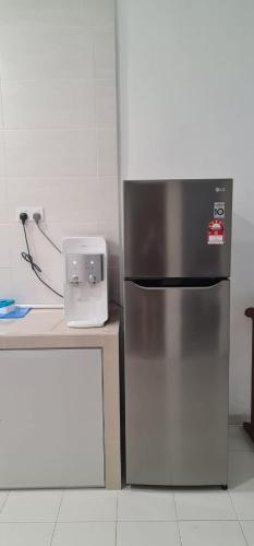 a kitchen with a stainless steel refrigerator and a counter at Voon 4 bedroom homestay Mersing in Mersing