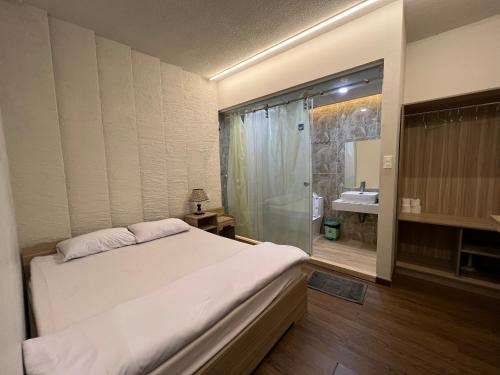 a bedroom with a bed and a bathroom with a shower at Cơ sở lưu trú du lịch Uyên Thanh 2 in Da Lat