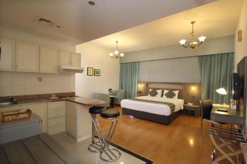 a hotel room with a bed and a kitchen at Florida City Hotel Apartments (Previously Flora Hotel Apartments) in Dubai