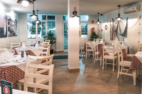 un comedor con mesas y sillas blancas en Aequora Lanzarote Suites en Puerto del Carmen