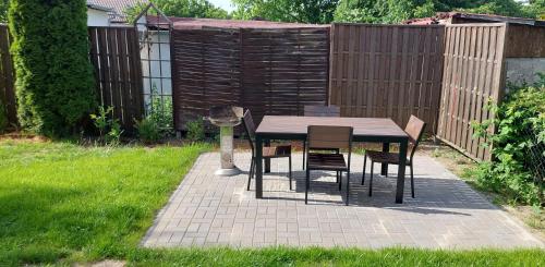 a table and chairs in a backyard with a fence at Apartmány Kousek od jezera in Doksy