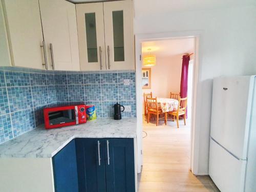 a kitchen with a red microwave on a counter top at Owl Haven: Comfortable central 3 bedroom house, with an enclosed garden. in Bicester