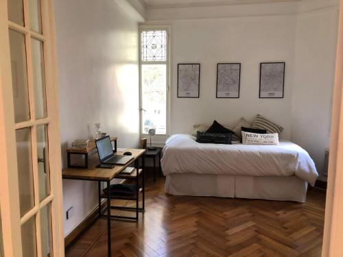 a bedroom with a bed and a desk with a laptop at MARY in Buenos Aires