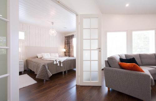 ein Schlafzimmer mit einem Bett, einem Sofa und einem Stuhl in der Unterkunft Holiday Villa Tonkokumpu - upea loma-asunto in Syöte