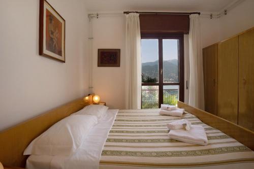 Schlafzimmer mit einem großen Bett und einem Fenster in der Unterkunft Villa Carolina in San Felice del Benaco