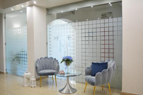 two chairs and a table in a room at Perla Hotel e Garden - Free Parking and Pool - Open area with Beautiful view of the Landscape in Capaccio-Paestum