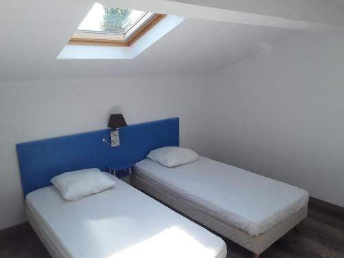 deux lits dans une chambre avec une fenêtre dans l'établissement Bord De Mer Vendres plage, à Vendres-Plage