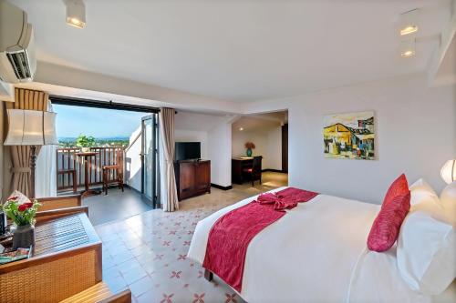 a hotel room with a bed and a balcony at RiverTown Hoi An Resort & Spa in Hoi An