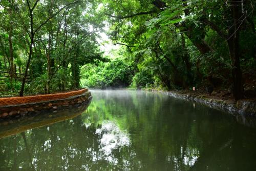 a river in a forest with mist in the water at Prime Hotel Águas da Serra in Rio Quente
