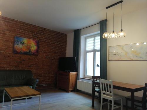 salon z kanapą i stołem w obiekcie Centrum Przy Promenadzie w mieście Mrągowo