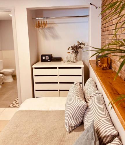 a bedroom with a bed and a dresser with pillows at Casa Reconquista in Mendoza