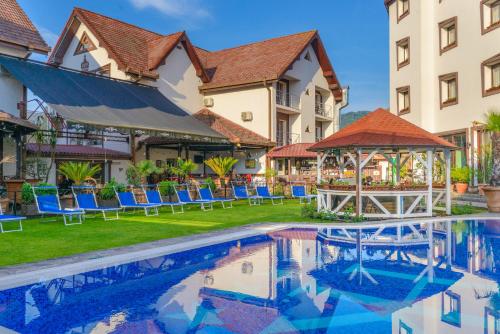 a hotel with a swimming pool in front of a building at Hotel Korona in Sighişoara