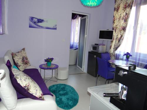 a living room with a white couch and blue chairs at Orange Flower Apartments 1 in Sofia
