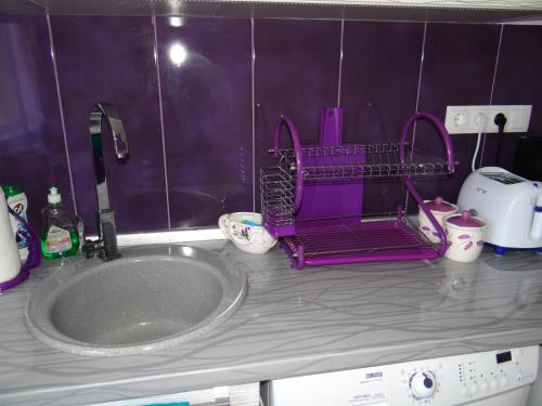 a bathroom sink with a pink drying rack on a counter at Orange Flower Apartments 1 in Sofia