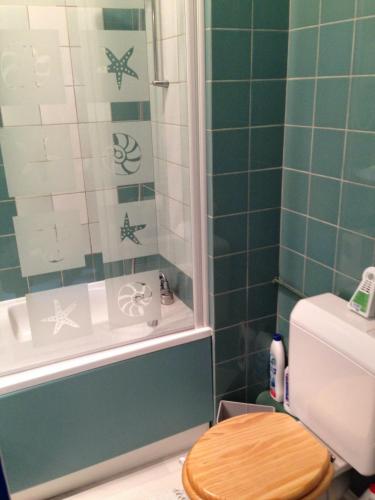 La salle de bains est pourvue d'une douche, de toilettes et d'une baignoire. dans l'établissement Chez Christine, à Ploemel