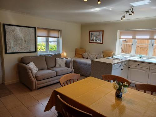 eine Küche und ein Wohnzimmer mit einem Sofa und einem Tisch in der Unterkunft Greystones Lodge in Swayfield