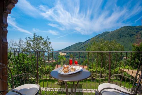 a table with a plate of food on a balcony with mountains at Il Casale del Contadino in Agerola