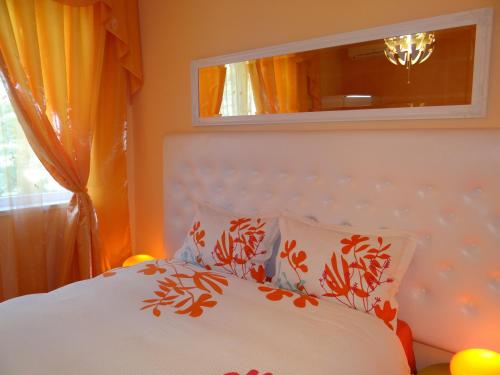 a bedroom with a bed with orange curtains and a mirror at Orange Flower Apartments 1 in Sofia