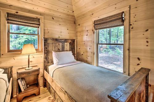 a bedroom with a bed in a log cabin at Lakefront Cottage Boat Dock, Patio and Kayaks! in Oxford