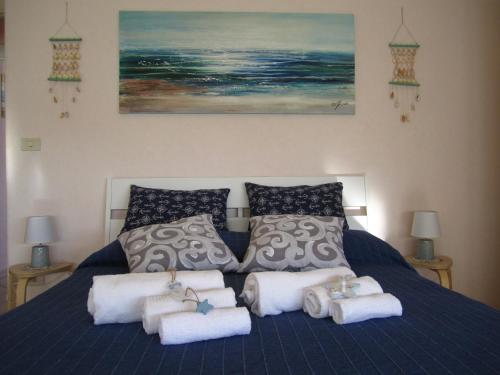 een slaapkamer met een blauw bed en handdoeken bij Alma Ùnica Fronte Mare in Lido di Ostia