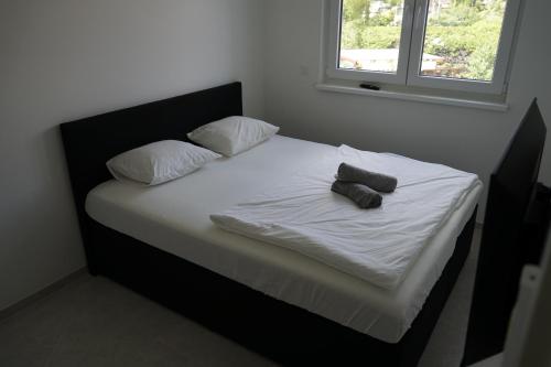 un letto con lenzuola bianche e 2 cuscini sopra di DM Apartment a Vienna