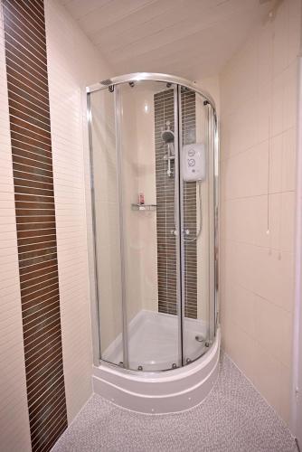 a shower with a glass door in a bathroom at The Hathaways in Stratford-upon-Avon