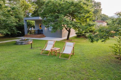 two lounge chairs and a table and chairs in a yard at Elena luxury living in Paralía Skotínis