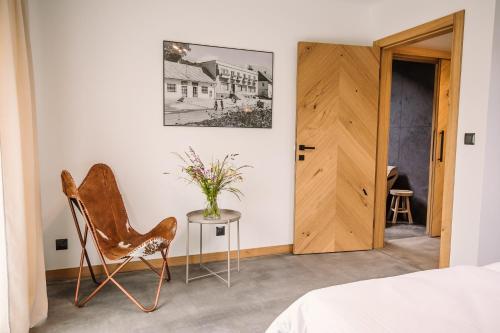1 dormitorio con silla, mesa y puerta en Apartamenty Na Potokach, en Żegocina