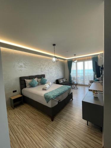 a bedroom with a bed and a desk in it at Апартаменти Генезис Ахтопол in Ahtopol