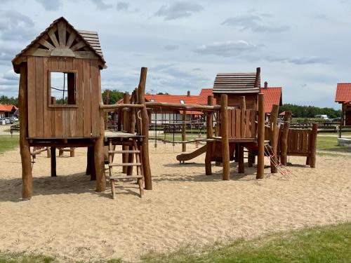 a group of wooden play structures in the sand at Kaszubska Odskocznia Ostoja Bukowo in Borowy Młyn