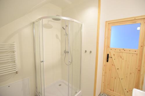 y baño con ducha y puerta de cristal. en Johnny House 2 en Suwałki