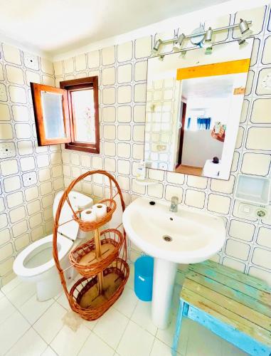 La salle de bains est pourvue d'un lavabo, de toilettes et d'un miroir. dans l'établissement Estilo ibicenco en todo, à San José