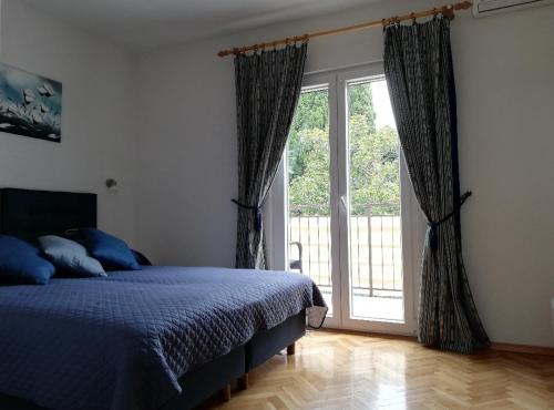 una camera da letto con un letto e una grande finestra di Lino Apartments a Rovigno (Rovinj)
