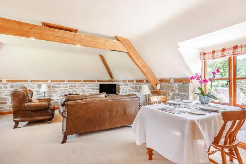 uma sala de estar com uma mesa e um sofá em Robin's Nest em Craven Arms
