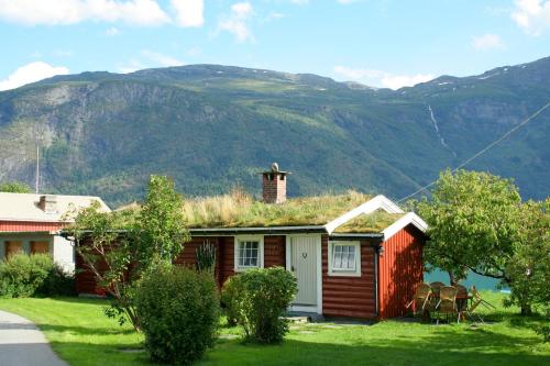 
a house with a mountain range and a clock tower at Dalsøren Camping og hytter in Luster
