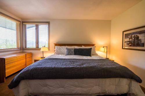 a bedroom with a large bed and two windows at Tamarak 36 in Snowmass Village