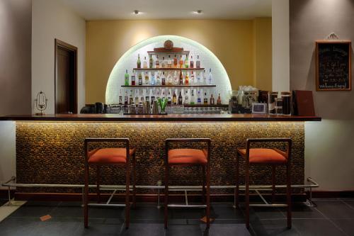 a bar with four stools in front of it at RiverTown Hoi An Resort & Spa in Hoi An