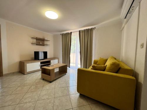 a living room with a yellow couch and a television at Haus Zdenka in Rab