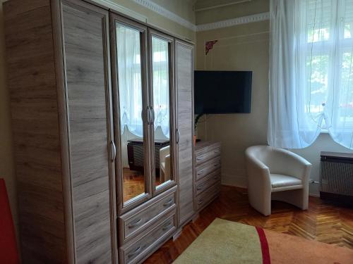 a bedroom with a dresser and a desk in a room at Szent István Wellness Panzió in Makó