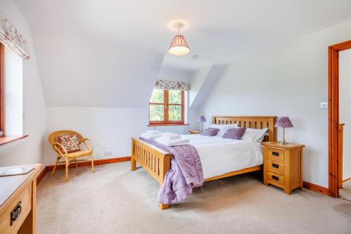 a bedroom with a bed and a chair and a window at Byne Brook Cottage in Wistanstow