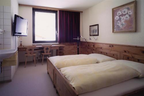 ブラントにあるApartment Familie Kinz im Haus Zalimのベッドルーム1室(ベッド2台、デスク、テレビ付)
